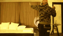 a man wearing a hoodie that says pon is standing in a bedroom