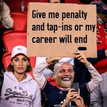 a man holds up a sign that says give me penalty and tap-ins or my career will end