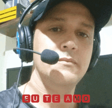 a man wearing headphones and a hat with eu te amo written in red