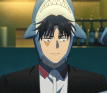 a man in a suit has a shark hat on