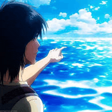 a man is pointing at the ocean while looking at it .