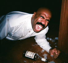 a man laying on the floor with a bottle of hennessy on the floor