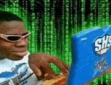 a man wearing sunglasses is typing on a blue laptop with the word sms on it .