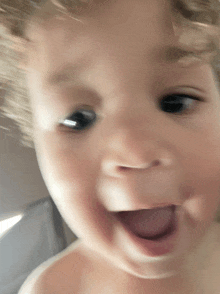 a close up of a baby 's face with his tongue hanging out