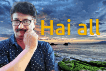 a man with glasses and a mustache is standing in front of a beach with the words hai all written on it