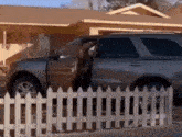 a car is parked in front of a house with its door open and a white picket fence behind it .