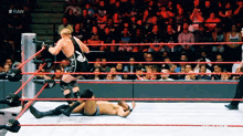 two wrestlers in a wrestling ring with the word raw on the bottom