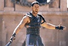 a man in a gladiator costume holds a sword in his hand