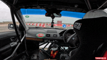 a driver in a race car with a sticker on the dashboard that says del arte