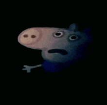 a close up of a stuffed pig with a scared face in the dark .