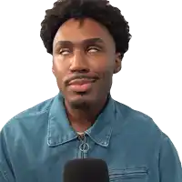 a man wearing a blue jacket is holding a microphone and making a face