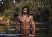 a shirtless man with long hair and a beard is standing in the water