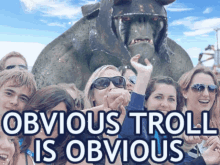 a group of people standing in front of a troll with obvious troll is obvious written on it