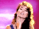 a woman with a ring on her finger touching her face