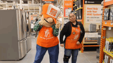 a home depot mascot and a woman pose in front of a sign that says need help with your hvac system