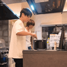 a man in a white shirt is cooking in a kitchen with labels japan written on the ceiling above him