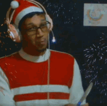 a man wearing headphones and a santa hat is opening a bottle of champagne