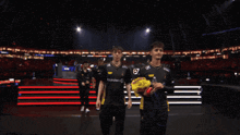 a man in a leclerc shirt stands next to a man in a yellow bag