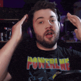 a man wearing headphones and a black shirt with the word powerline on it