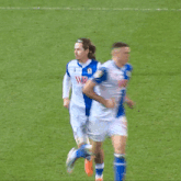 a soccer player with the number 10 on his shorts is running towards another player