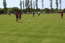 a group of soccer players on a field with trees in the background