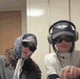 two women wearing hats and headphones are standing next to each other