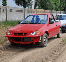 a red suzuki car has googly eyes painted on the front