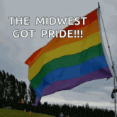 a rainbow flag is flying in the wind with the words " the midwest got pride " above it