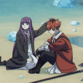 a boy and a girl are sitting on the ground and the girl is touching the boy 's hair