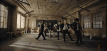 a group of men in suits and ties are dancing in an empty classroom .