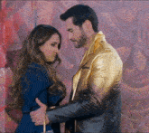 a man in a gold jacket holds a woman in a blue jacket