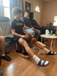 a man sitting on a rocking horse wearing a shirt that says washington griffins