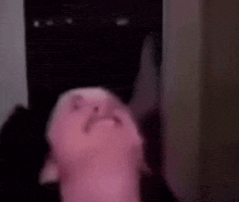a pink stuffed animal is sitting in a dark room with its mouth open .