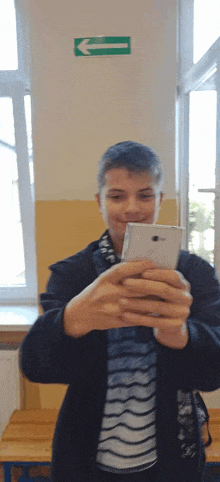 a young man is taking a picture of himself with his cell phone .