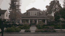 a man walking in front of a house that has a license plate that says ' lg ' on it