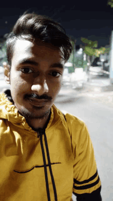 a man wearing a yellow shirt with the letter t on the front