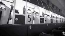 a black and white photo of a locker room with a number 5 on the back of a player 's jersey