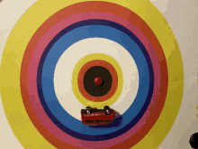 a red toy car is in the center of a colorful circle