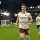 a soccer player wearing a white shirt that says emirates