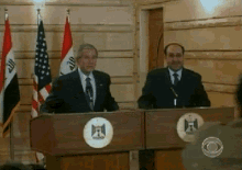 a man in a suit and tie stands behind a podium with a emblem that says ' egypt ' on it