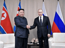 two men are shaking hands in front of flags