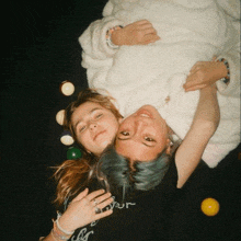 two girls laying on their backs with one wearing a shirt that says ' your ' on it