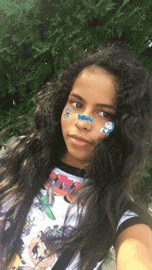 a young girl with stickers on her face including one that says doraemon