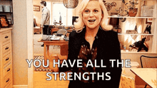 a woman is standing in a living room with the words `` you have all the strengths '' written above her .