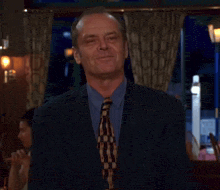 a man in a suit and tie is waving