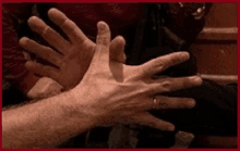 a man 's hands are reaching out towards another man 's hands