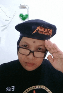 a woman wearing glasses and a beret that says aubijate