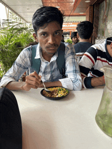 a man sits at a table with a plate of food and a sign that says medical & general