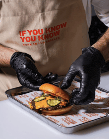 a man wearing a apron that says if you know you know