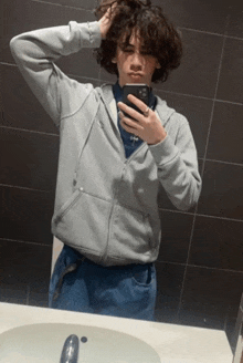 a man taking a picture of himself in a bathroom mirror